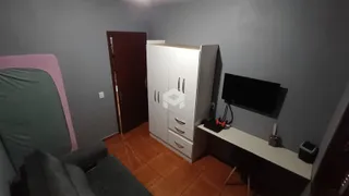Quarto com cama e armário branco em ambiente de sala.
