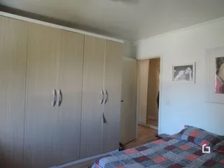 Quarto com armário de madeira e cama visível.