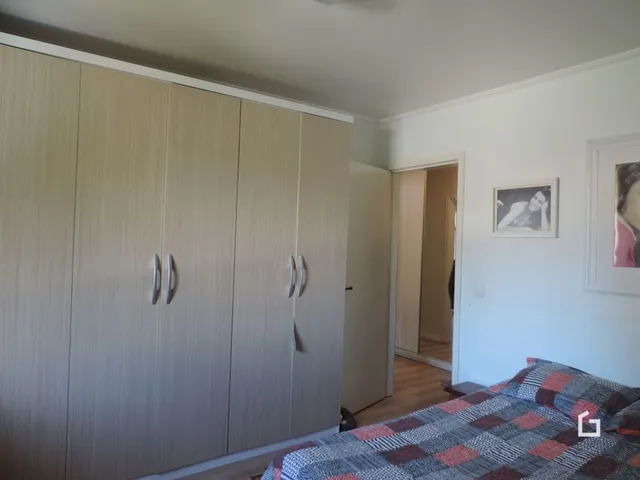 Quarto com armário de madeira e cama visível.