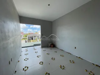 Vista interna de um ambiente amplo em construção com piso de concreto.