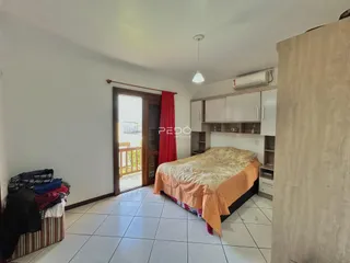 Quarto com piso de cerâmica e armário branco.