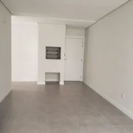 Foto de um corredor interno com paredes brancas e piso cinza.