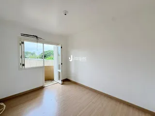 Sala de estar com piso de madeira clara e porta de vidro abrindo para o exterior.