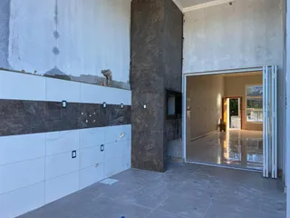 Hall de entrada com revestimento de painéis e coluna de concreto aparente.