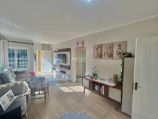 Sala de estar iluminada com piso de cerâmica e móveis.