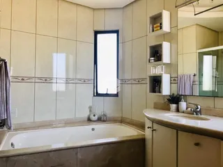 Foto de um banheiro com azulejos e banheira em uma residência.