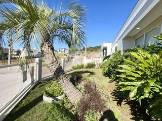 Vista da fachada de uma residência com jardim e vegetação.