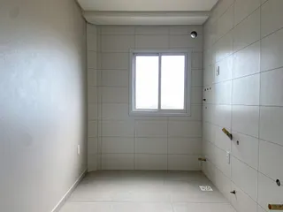 Foto de um corredor interno com paredes brancas e piso claro.