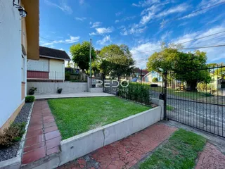Vista da fachada de uma residência com jardim e cerca em Lajeado, Brasil.
