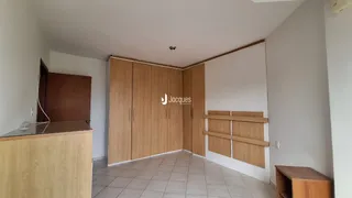 Interior de um ambiente com armários de madeira e piso cerâmico.