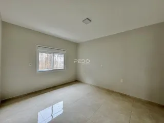 Sala de estar com piso de cerâmica e janela na parede.