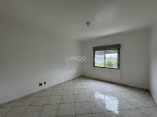 Ambiente interno de uma sala com piso de cerâmica clara e paredes brancas.