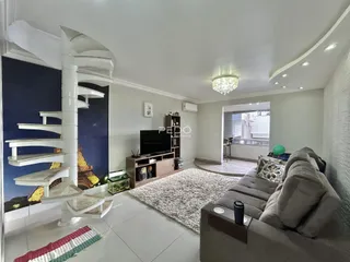 Sala de estar com escadaria e sofá em ambiente claro.