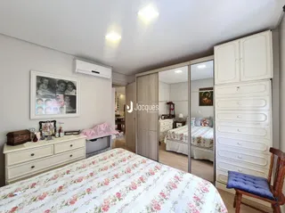 Quarto com armários brancos e cama decorada em uma residência.