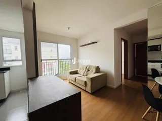 Sala de estar com sofá e piso de madeira em um apartamento no Brasil.