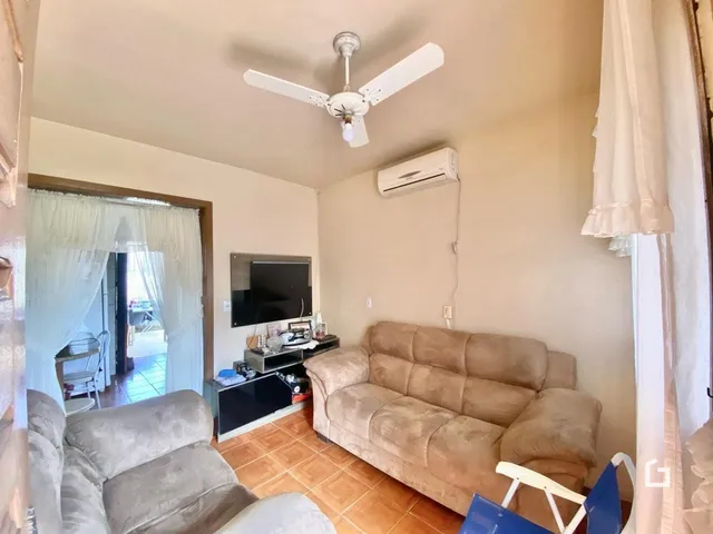 Sala de estar com sofá e televisão em um imóvel.