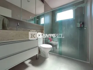Foto de um banheiro interno com box de vidro e bancada branca.
