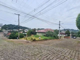 Vista da fachada de uma propriedade com pavimentação de paralelepípedos.