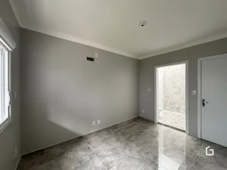 Vista interna de uma sala com piso de cerâmica e paredes cinzas.