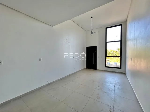 Ambiente interno de uma sala com paredes brancas e piso claro.