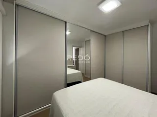 Foto de um quarto com armários e cama de casal em um imóvel.
