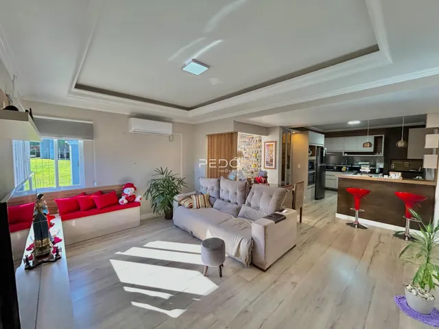Sala de estar de um imóvel em Lajeado, Brasil, com piso de madeira e sofá claro.