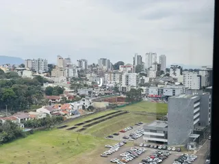 Vista aérea de uma área residencial com grandes espaços verdes e estacionamento.