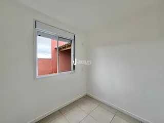 Vista interna de uma sala com paredes brancas e piso de cerâmica.