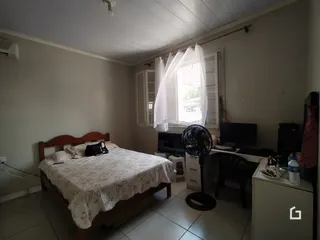 Quarto com cama de madeira e janela.