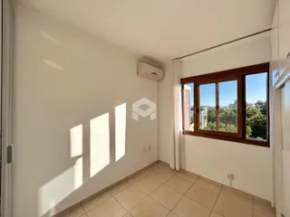 Ambiente interno com piso de cerâmica e janela de madeira.