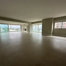 Sala ampla com piso claro e grande janela de vidro.
