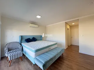 Quarto com cama azul e poltrona decorativa.