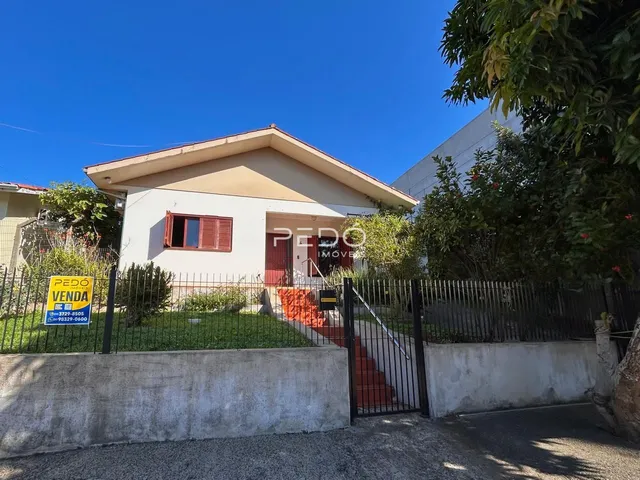 Fachada de uma casa em Lajeado, Brasil, com cerca e portão de ferro.