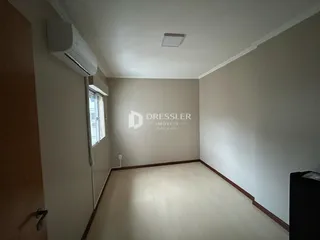 Ambiente interno de uma sala com piso de madeira e ar-condicionado instalado.