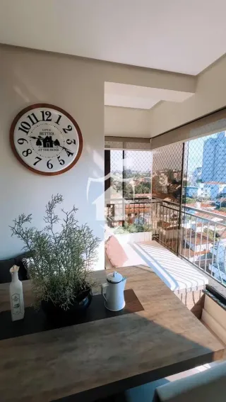 Interior de uma sala com piso de madeira e parede clara.