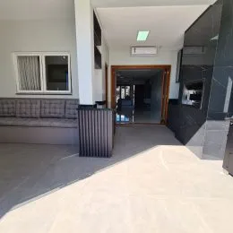 Hall de entrada com piso claro e janela.