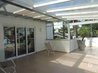 Vista da sala de estar com portas de vidro que dão acesso ao exterior.