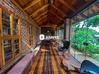 Hall de entrada com paredes de tijolo aparente e piso de madeira.