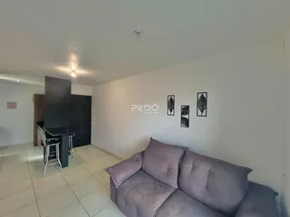 Sala de estar com sofá e parede decorada em um imóvel no Brasil.