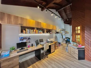 Ambiente interno de um imóvel com decoração em madeira e espaço de trabalho.