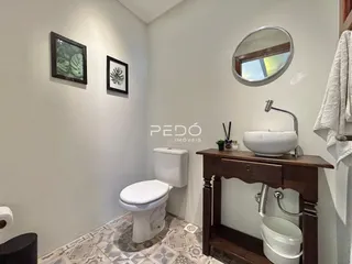 Foto de um banheiro com piso de cerâmica e louças brancas.