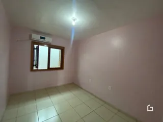 Foto interna de um cômodo com piso de cerâmica e janela.