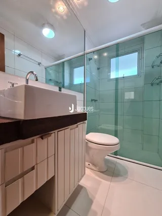 Foto de um banheiro moderno com revestimento cerâmico e box de vidro.