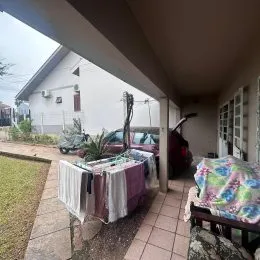 Foto de uma área externa com piso de concreto e vegetação.