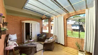 Uma área coberta com paredes de tijolos e móveis de vime é visível na propriedade.