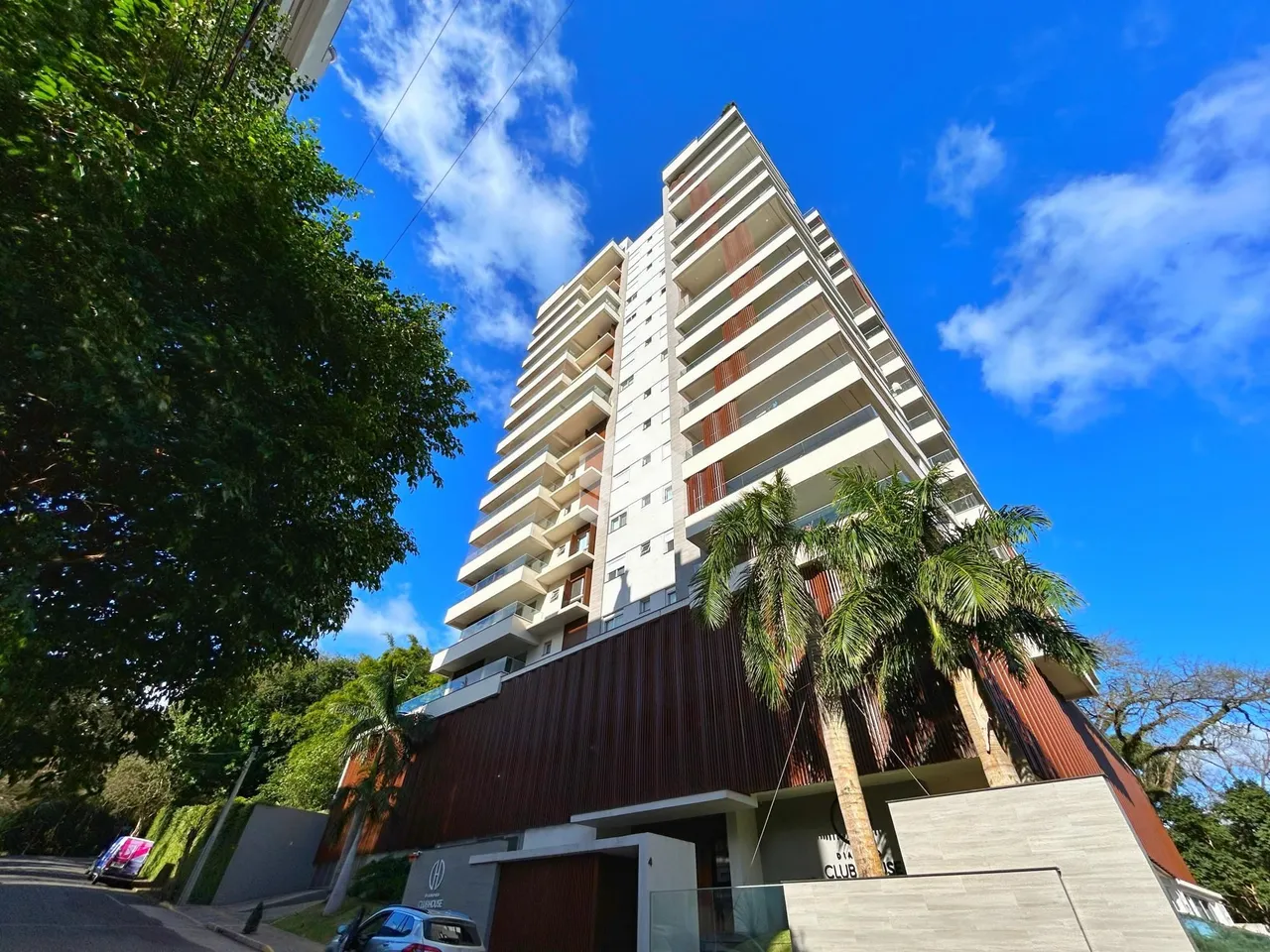 Fachada de um prédio residencial em Lajeado, Brasil, com vegetação ao redor.