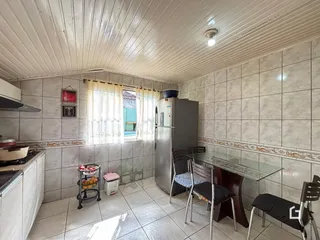 Imagem de uma cozinha ou área comum com paredes de azulejo e janela.