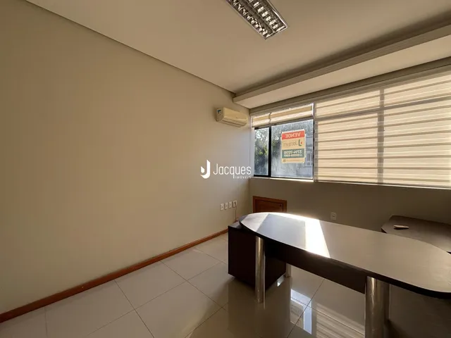 Ambiente interno de uma sala ampla com piso de cerâmica e janela.