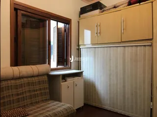 Sala de estar com sofá e janela de madeira em um imóvel no Brasil.
