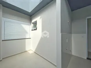 Vista interna de um ambiente com paredes brancas e piso claro.